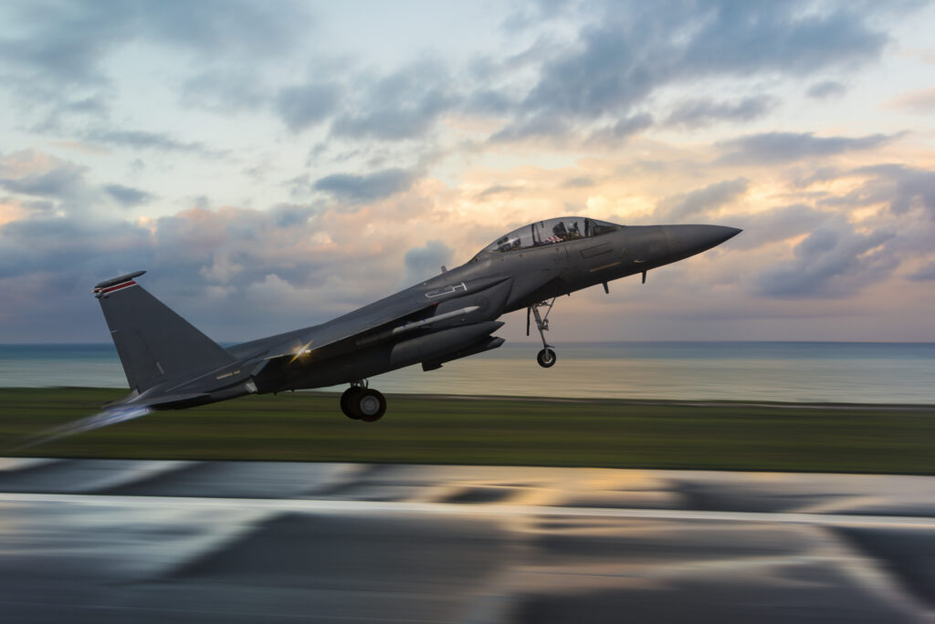 F-15 Fihter Jet taking off at sunset as an aircraft in the aerospace and defense industry.