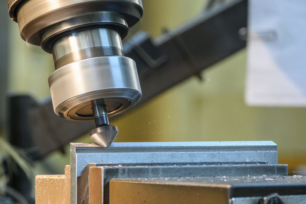 The edge finishing process using chamfering on a metal plate using a numerical control (NC) milling machine. The edges are being deburred to create a consistent bevel profile using a chamfer tool (either indexable or solid carbide), improving handling safety and preparing the workpiece for subsequent assembly.